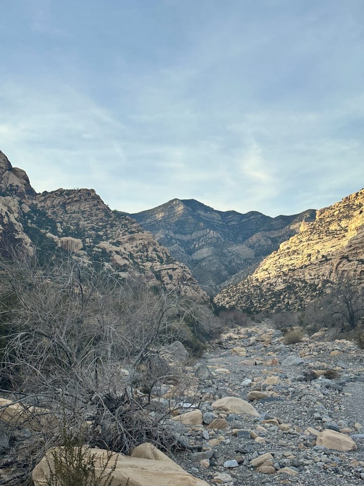 A valley opening above on a rocky river bed.